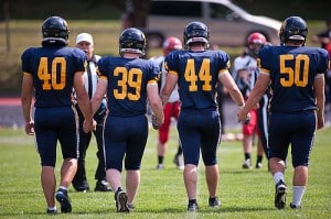 Sports, Yoga and Meditation Together - Providence Holistic Counseling Services-football team holding hands carleton